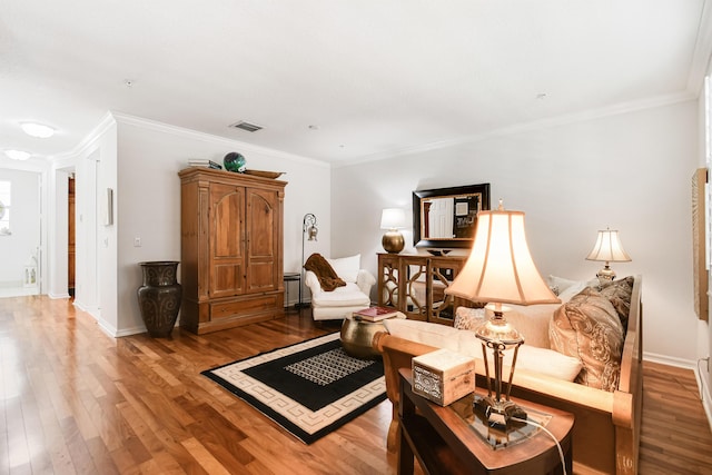 sitting room with wood-type flooring and crown molding