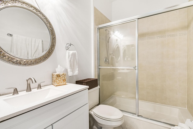 bathroom with vanity, toilet, and a shower with shower door