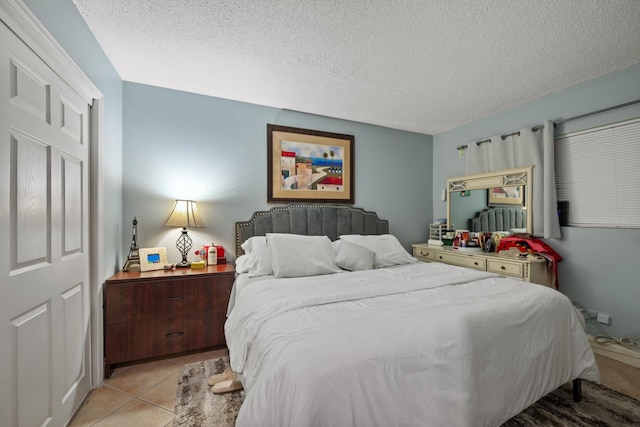 bedroom with a textured ceiling and light tile patterned flooring