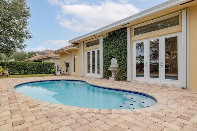 view of pool with french doors and a patio