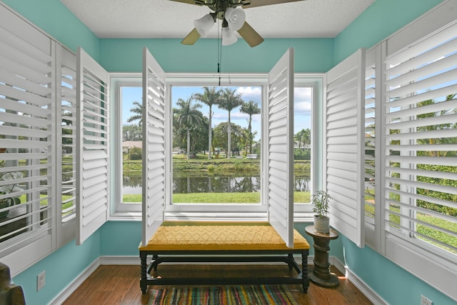 sunroom / solarium with a water view and ceiling fan