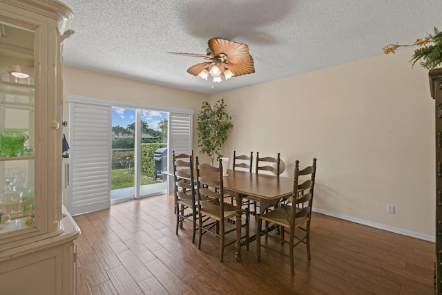 dining room with ceiling fan, dark hardwood / wood-style flooring, and a textured ceiling