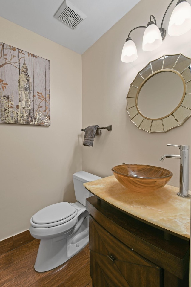 bathroom featuring vanity, hardwood / wood-style flooring, and toilet