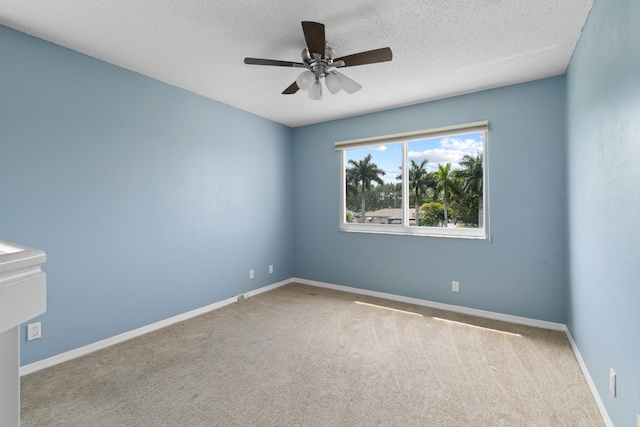 carpeted empty room with a textured ceiling and ceiling fan