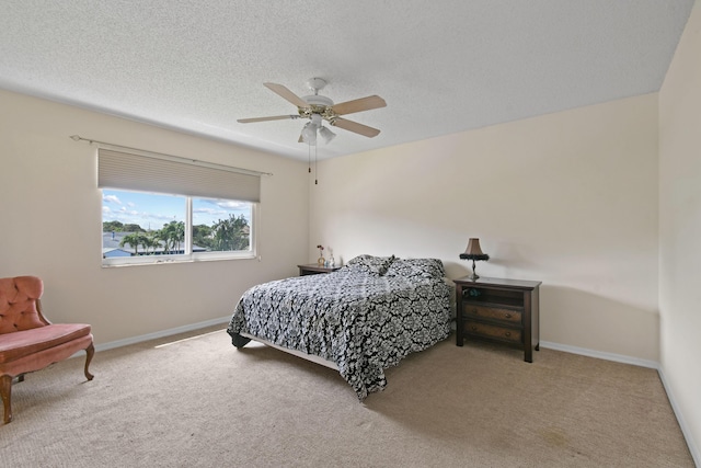 carpeted bedroom with ceiling fan and a textured ceiling