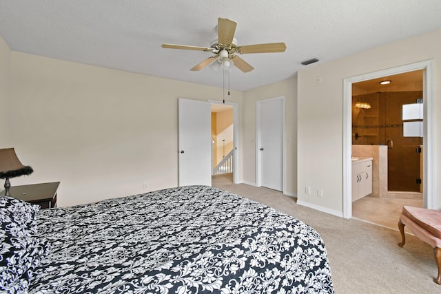 bedroom featuring ensuite bath, light carpet, ceiling fan, and a textured ceiling