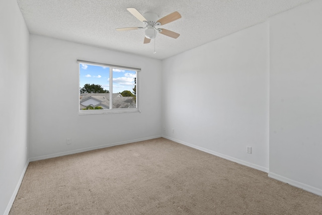 spare room featuring carpet flooring, a textured ceiling, and ceiling fan