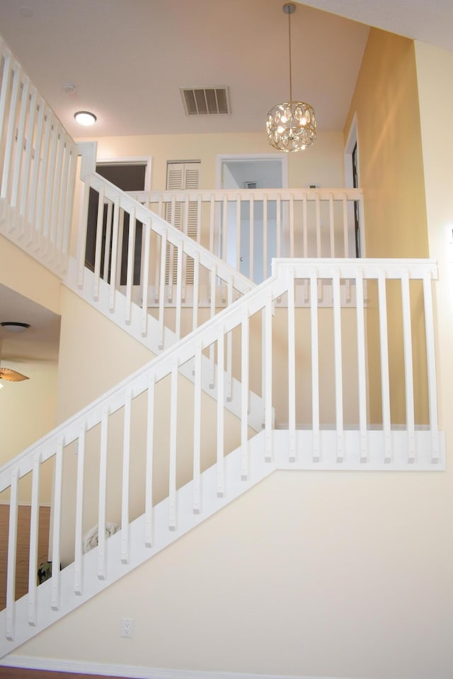 stairs featuring a chandelier