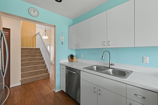 kitchen featuring dark hardwood / wood-style flooring, a textured ceiling, stainless steel appliances, sink, and white cabinets