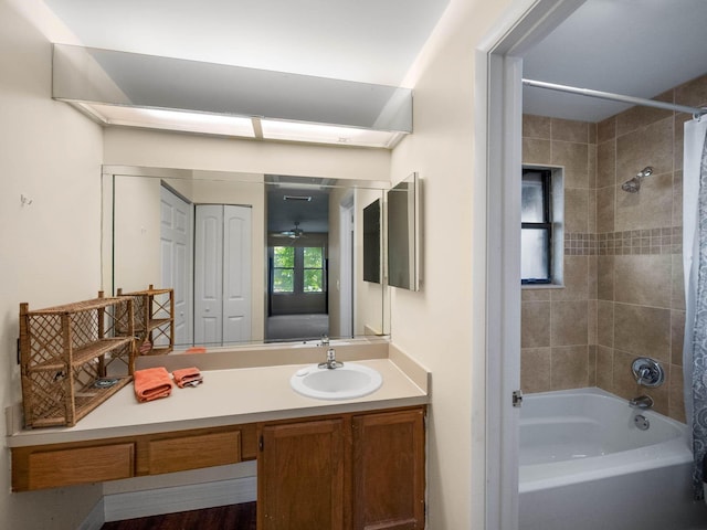 bathroom with shower / bath combination with curtain, vanity, and ceiling fan