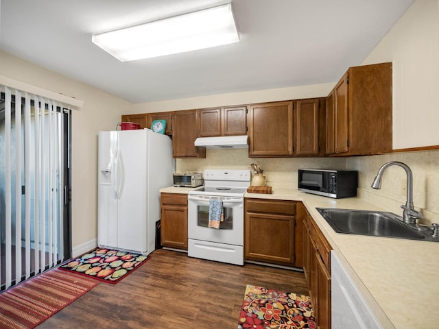 kitchen with decorative backsplash, white appliances, dark hardwood / wood-style floors, and sink