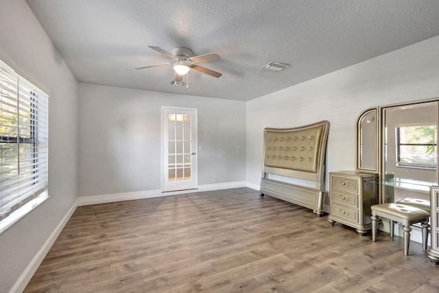 interior space with ceiling fan, french doors, a textured ceiling, and hardwood / wood-style flooring