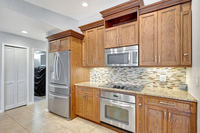 kitchen featuring light stone countertops, appliances with stainless steel finishes, and light tile patterned floors