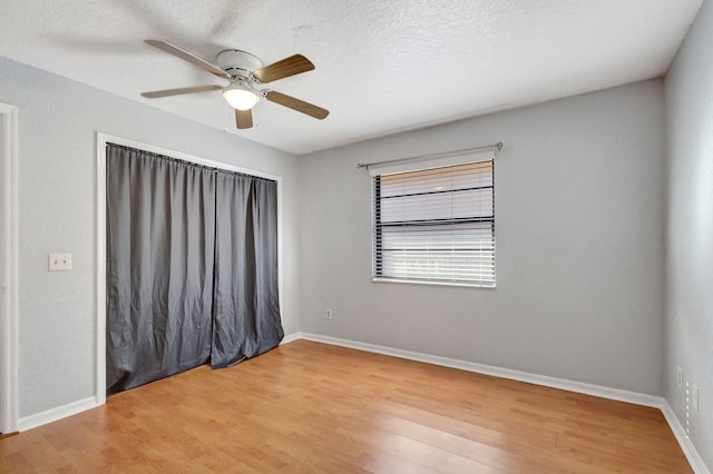 spare room with hardwood / wood-style flooring, ceiling fan, and a textured ceiling