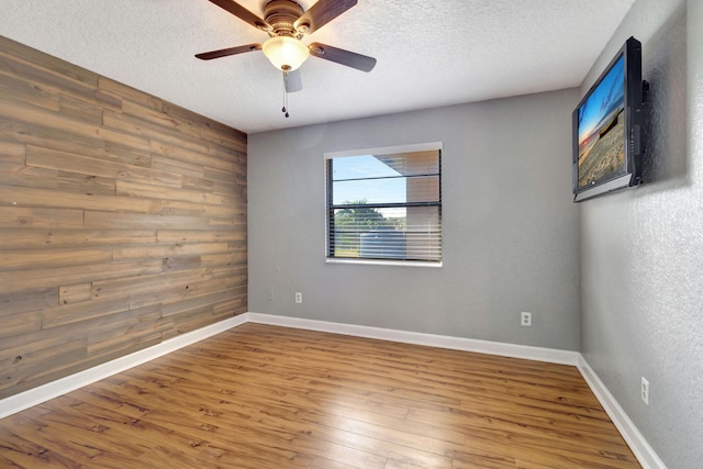 unfurnished room with hardwood / wood-style floors, a textured ceiling, and ceiling fan