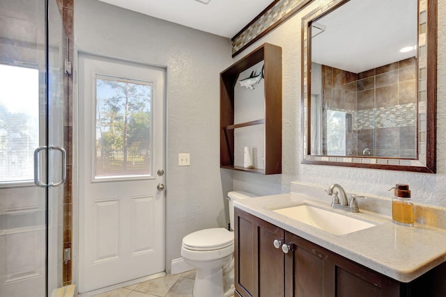 bathroom with a wealth of natural light, tile patterned flooring, vanity, and walk in shower