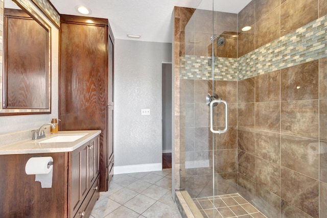 bathroom featuring tile patterned flooring, vanity, and a shower with door