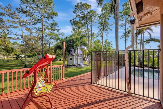 wooden deck with a lawn and a swimming pool