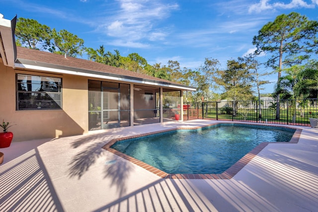 view of pool with a sunroom and a patio