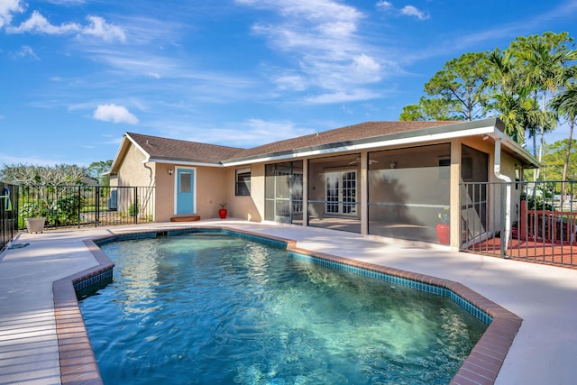 view of swimming pool with a sunroom, ceiling fan, and a patio