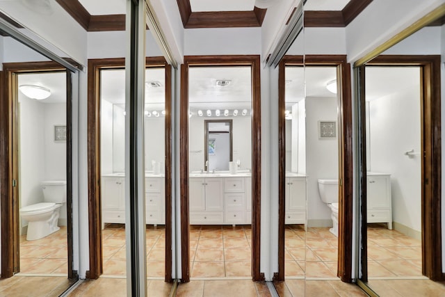 bathroom with tile patterned flooring, vanity, toilet, and crown molding