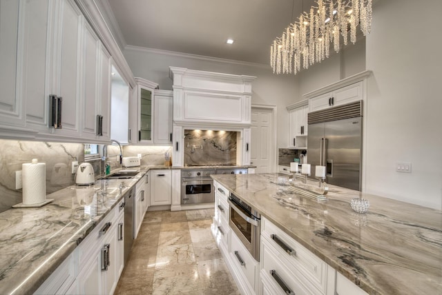 kitchen featuring white cabinets, sink, hanging light fixtures, a notable chandelier, and stainless steel appliances