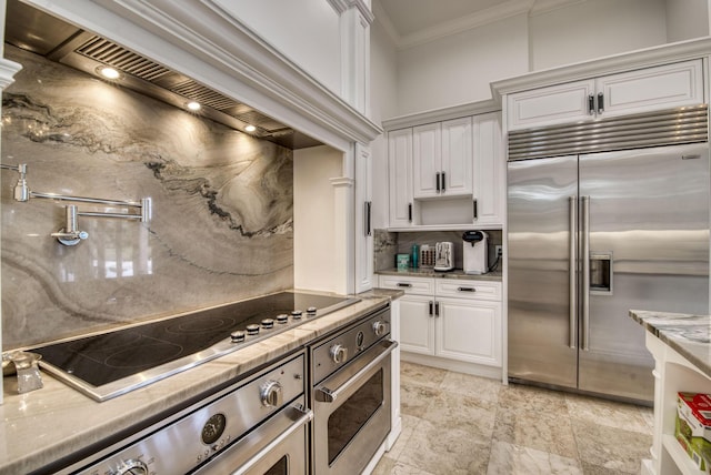 kitchen featuring light stone countertops, white cabinetry, crown molding, and stainless steel appliances