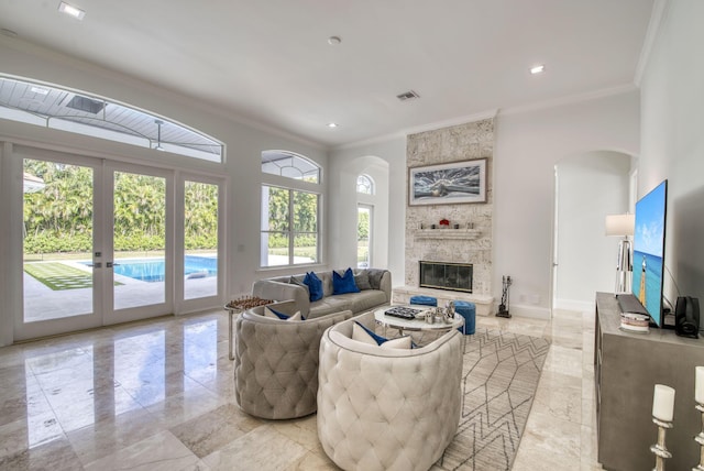 living room with a fireplace, french doors, and ornamental molding