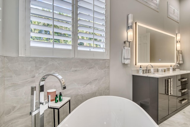 bathroom featuring vanity, a bath, and tile walls