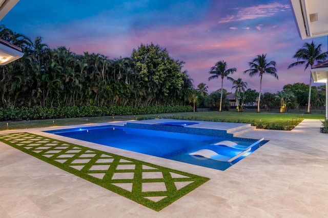 pool at dusk with a patio area and a yard