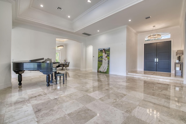 foyer featuring plenty of natural light, crown molding, and a notable chandelier