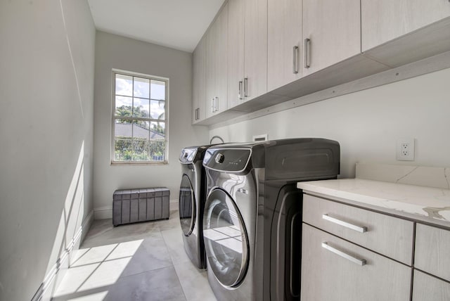 laundry area with separate washer and dryer and cabinets