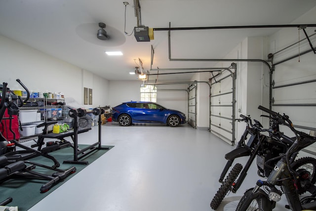 garage with electric panel, a garage door opener, and ceiling fan