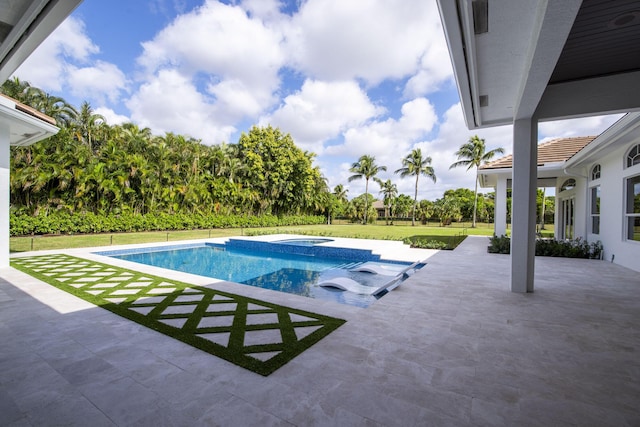 view of swimming pool featuring a lawn, a patio area, and an in ground hot tub