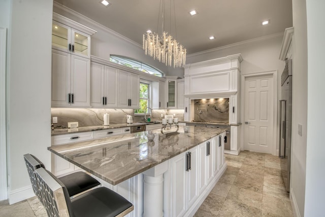 kitchen with light stone countertops, pendant lighting, a large island, and a breakfast bar area