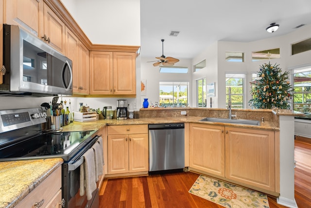 kitchen with kitchen peninsula, appliances with stainless steel finishes, dark hardwood / wood-style floors, and ceiling fan