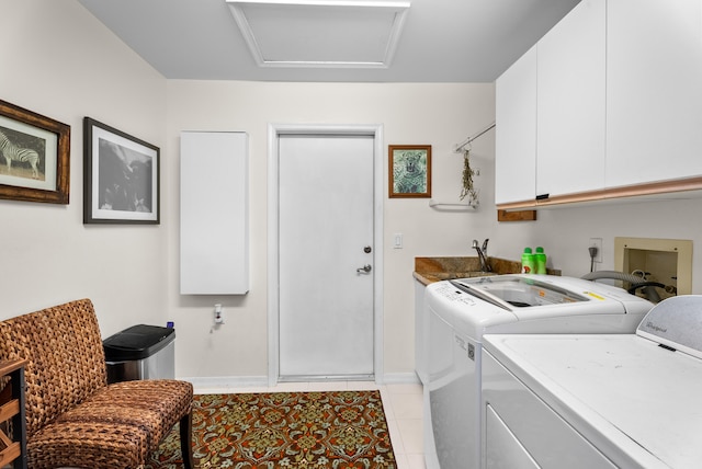 washroom with cabinets, sink, light tile patterned floors, and washer and dryer