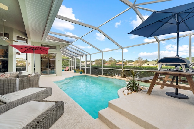 view of pool featuring glass enclosure, an outdoor living space, and a patio