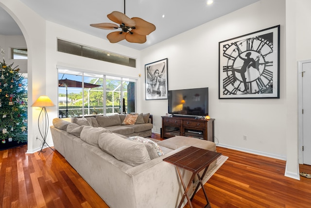 living room featuring ceiling fan and dark hardwood / wood-style floors