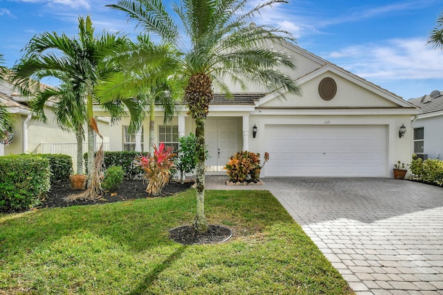 view of front of property with a garage and a front lawn