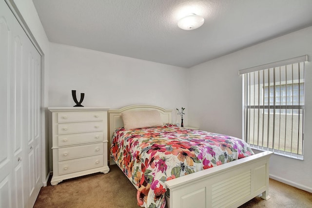 carpeted bedroom with a textured ceiling and a closet