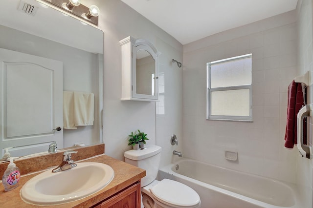 full bathroom with vanity, tiled shower / bath combo, and toilet