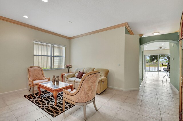 living room with ceiling fan, light tile patterned floors, and ornamental molding