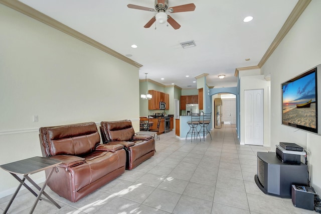 living room with ceiling fan with notable chandelier, light tile patterned floors, and ornamental molding