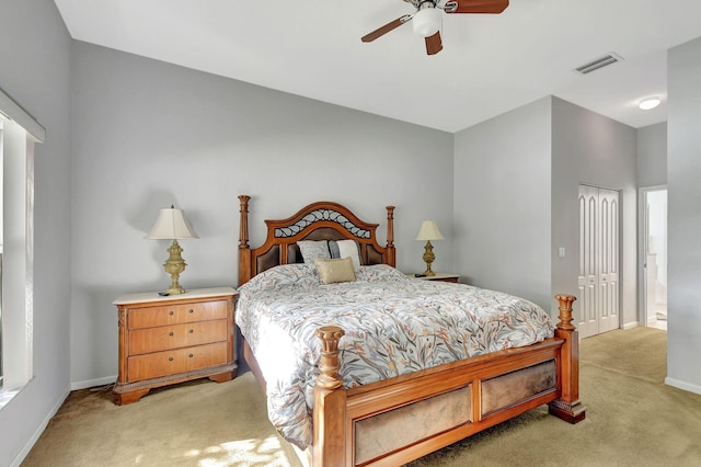 bedroom featuring ceiling fan, light colored carpet, and a closet