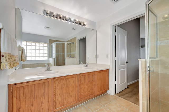 bathroom with tile patterned floors, a shower with door, and vanity