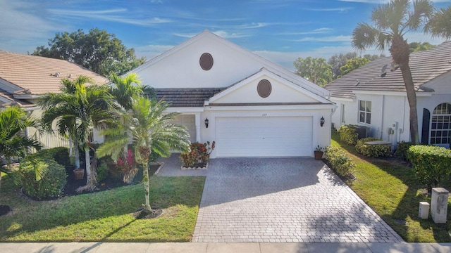 view of front facade with central AC, a garage, and a front lawn