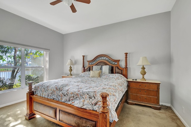 carpeted bedroom with ceiling fan and vaulted ceiling