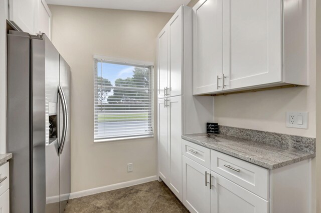 kitchen featuring white cabinets, sink, appliances with stainless steel finishes, light tile patterned flooring, and light stone counters