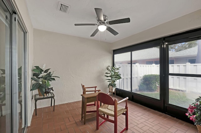 sunroom featuring ceiling fan and plenty of natural light